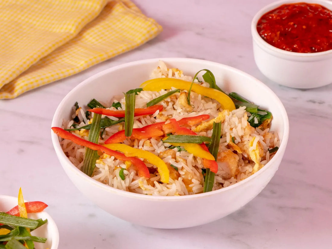 Aussie takeaway-style fried rice with egg, colourful capsicum and spring onions served in a white bowl.
